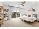 Bright main bedroom featuring a ceiling fan, balcony access, and stylish decor for a relaxing retreat at 9391 E 59Th North Pl, Denver, CO 80238