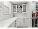 Pantry with glass door cabinets, white backsplash, and stainless steel wine cooler at 9391 E 59Th North Pl, Denver, CO 80238