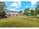Expansive backyard features lush green grass, patio, partial fence, and exterior home view at 4522 S Robb St, Littleton, CO 80127