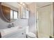Bathroom with a vanity, a round mirror, drawers, shelving, a toilet, and a shower stall at 4522 S Robb St, Littleton, CO 80127