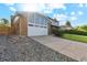 Two car garage with brick and blue siding and ample parking space at 4522 S Robb St, Littleton, CO 80127