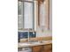 Kitchen sink beneath window with modern faucet, light countertop, and dark wooden cabinetry at 4522 S Robb St, Littleton, CO 80127