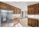 Spacious kitchen with wood cabinets, stainless steel refrigerator, and tile flooring at 4522 S Robb St, Littleton, CO 80127