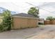 Detached garage painted in neutral tones with a window accent and surrounded by greenery at 4453 Fillmore St, Denver, CO 80216