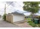 Detached garage with white door and neutral paint matching house and yard featuring mature trees at 4453 Fillmore St, Denver, CO 80216