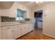 Traditional kitchen with white cabinetry, a window over the sink, and hardwood flooring at 4453 Fillmore St, Denver, CO 80216