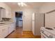 A classic kitchen featuring white appliances, wooden floors, and access to a laundry area at 4453 Fillmore St, Denver, CO 80216
