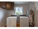 Functional laundry room featuring a washer, dryer, water heater, overhead cabinet, and natural light at 4453 Fillmore St, Denver, CO 80216