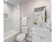 Bathroom featuring tiled shower and tub, single sink vanity, and modern fixtures at 4733 E Iliff Ave, Denver, CO 80222