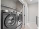 Convenient laundry room featuring modern black and silver washer and dryer units at 4733 E Iliff Ave, Denver, CO 80222