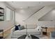 Comfortable living room featuring a neutral-colored sofa and staircase access at 4733 E Iliff Ave, Denver, CO 80222