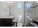 Bathroom featuring a single sink vanity, a toilet, and a glass-enclosed shower with pebble details at 19055 E 55Th Ave, Denver, CO 80249