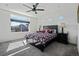 Bedroom featuring carpet, neutral walls, a black ceiling fan, a large window, and a dark wood bed frame at 19055 E 55Th Ave, Denver, CO 80249