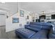 Comfortable living room featuring a blue sectional sofa, staircase, and access to the kitchen at 19055 E 55Th Ave, Denver, CO 80249