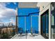 Balcony furnished with two chairs features blue storage doors and cityscape views, perfect for relaxation at 3198 Blake St # 502, Denver, CO 80205
