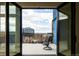 Inviting balcony with chairs, offering a pleasant cityscape view with modern buildings and blue skies at 3198 Blake St # 502, Denver, CO 80205