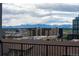 Scenic view from the balcony overlooking a city skyline with majestic mountains in the distance at 3198 Blake St # 502, Denver, CO 80205