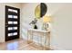 Modern entryway with a white and gold console table, decorative mirror, and a stylish black front door at 1630 S Valentine Way, Lakewood, CO 80228