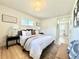 Bright main bedroom with wood floors, neutral walls, king bed, and bathroom access at 1630 S Valentine Way, Lakewood, CO 80228