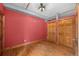 Bedroom featuring hardwood floors, a red accent wall, and two large closets for ample storage space at 3299 Lowell Blvd # 204, Denver, CO 80211