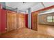 Cozy bedroom with hardwood floors, red accent wall, and two large closets, leading to the living area at 3299 Lowell Blvd # 204, Denver, CO 80211