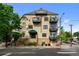 Multi-level condo building boasting several balconies, a street view and manicured landscaping at 3299 Lowell Blvd # 204, Denver, CO 80211
