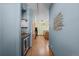 Hallway leading to kitchen with wood floors and mini fridge at 3299 Lowell Blvd # 204, Denver, CO 80211