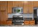 Close-up of the stainless steel gas range and microwave against granite countertops and wooden cabinets at 3299 Lowell Blvd # 204, Denver, CO 80211