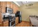 Updated kitchen with stainless steel appliances, including a gas range and microwave, and wooden cabinets at 3299 Lowell Blvd # 204, Denver, CO 80211