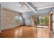 Bright living area with a sliding glass door to the balcony, exposed ductwork, and a brick accent wall at 3299 Lowell Blvd # 204, Denver, CO 80211