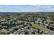 Wide aerial view of a residential neighborhood with lush greenery, streets, and mountain views in the distance at 11866 High Desert Rd, Parker, CO 80134