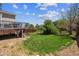 Expansive backyard with lush lawn, wood fence, mature trees, and deck access at 11866 High Desert Rd, Parker, CO 80134