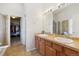 Bright bathroom features a double vanity, decorative tile flooring, and a glass-enclosed shower at 11866 High Desert Rd, Parker, CO 80134