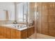 Relaxing bathroom features a soaking tub and a separate glass-enclosed shower with tile surround at 11866 High Desert Rd, Parker, CO 80134