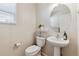 Cozy powder room with a pedestal sink and decorative mirror at 11866 High Desert Rd, Parker, CO 80134