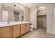 Bathroom with double vanity, tile floors, and walk-in closet access at 8707 E Florida Ave # 709, Denver, CO 80247
