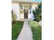 Welcoming entryway with black metal gate, white pillars, lush front yard landscaping at 2789 S Ivan Way, Denver, CO 80227