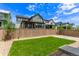 Large, fenced backyard with lush green lawn, gravel landscaping, and blue skies at 5608 Grandville Ave, Longmont, CO 80503