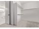 Bright closet features two clothing rods and opens to a modern bathroom with white tile and a tub at 5608 Grandville Ave, Longmont, CO 80503