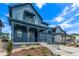 Blue two-story home featuring a covered porch, tasteful landscaping, and a two-car garage at 5608 Grandville Ave, Longmont, CO 80503
