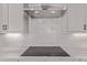 Close-up of modern induction cooktop and backsplash in a newly remodeled kitchen at 5608 Grandville Ave, Longmont, CO 80503