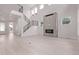 Bright, modern living room features a sleek fireplace, minimalist staircase, and light hardwood floors at 5608 Grandville Ave, Longmont, CO 80503