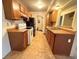 Galley-style kitchen with wood cabinets and tile flooring at 1074 S Dearborn St # 306, Aurora, CO 80012