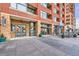 Building entrance with a restaurant facade, featuring modern doors, outdoor dining, and planters at 2100 16Th St # 408, Denver, CO 80202