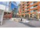 Exterior view of the building with a pedestrian bridge and ground-level dining area at 2100 16Th St # 408, Denver, CO 80202