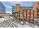 Brick exterior shows architectural details and access bridge under a partly cloudy sky at 2100 16Th St # 408, Denver, CO 80202