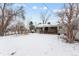 Large backyard with covered deck, great for outdoor activities and relaxation in a snowy landscape at 7135 W 24Th Ave, Lakewood, CO 80214