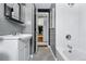 Clean bathroom featuring subway tile, a modern sink and fixtures, and an open doorway at 7135 W 24Th Ave, Lakewood, CO 80214