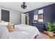 Cozy bedroom features navy accent wall, modern decor, natural light, and hardwood floors at 7135 W 24Th Ave, Lakewood, CO 80214