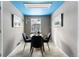 Bright and airy dining room with blue ceiling, grey walls, art, and a round wood table at 7135 W 24Th Ave, Lakewood, CO 80214